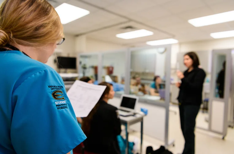 Nursing student reviewing notes during lecture