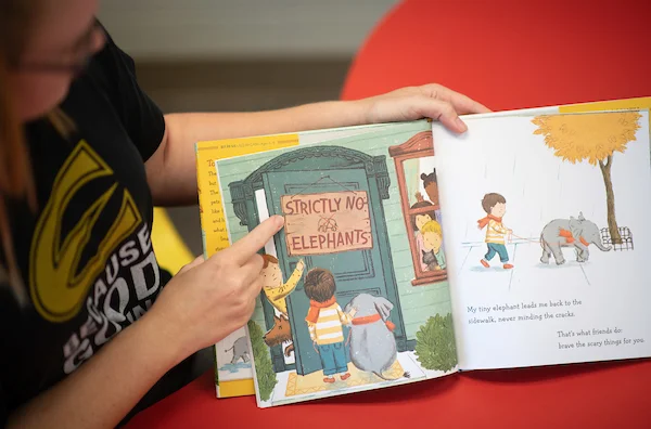 Elementary teacher reading book to elementary students