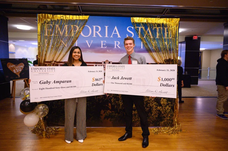 Photo of students Gaby Amparan and Jack Jewett holding giant scholarship checks