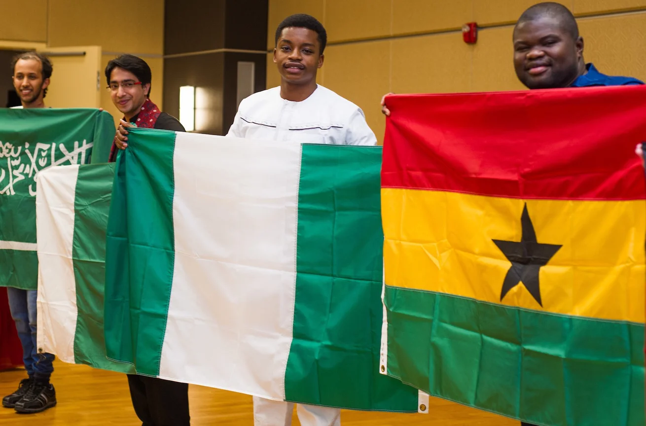 Emporia State international students posing with home flags