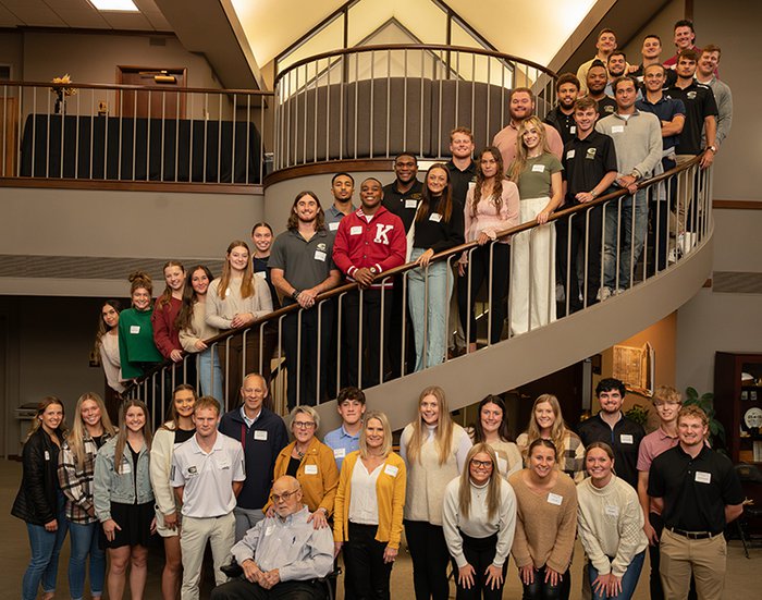 A group of students standing on a spiral staircase